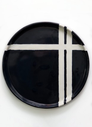 Hand-made dish with flat sides of black color with white stripes