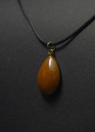 The pendant is orange-black. Drop1 photo