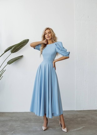 An elegant, midi-length blue dress with an open back